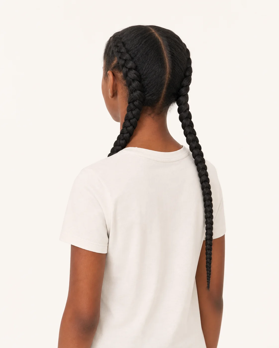 Girl from behind wearing a plain warm-white t-shirt, hair in two braids